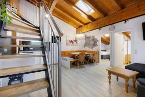 a living room with a staircase and a dining room at Goodlife B10 in Saalbach-Hinterglemm