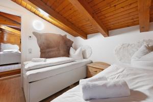 a bedroom with two beds and a wooden ceiling at Goodlife B10 in Saalbach-Hinterglemm