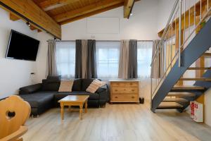 a living room with a couch and a staircase at Goodlife B10 in Saalbach-Hinterglemm