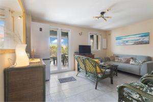 a living room with a couch and a table at Maison Goéland in Le Barcarès