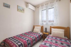 a bedroom with two beds and a window at Maison Goéland in Le Barcarès +26 photos