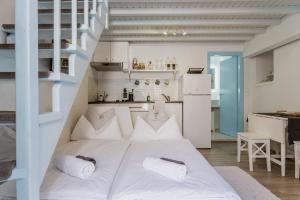 a large white bed in a room with a kitchen at 5-Bed Stylish Maisonette in Mikonos