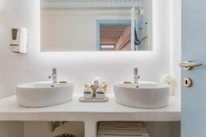 a bathroom with two sinks and a mirror at 5-Bed Stylish Maisonette in Mikonos