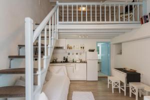 a kitchen and a living room with a spiral staircase at 5-Bed Stylish Maisonette in Mikonos +14 photos