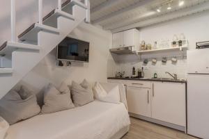 a living room with a white couch and a kitchen at 5-Bed Stylish Maisonette in Mikonos