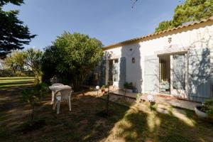 a white house with a table in the yard at Chambres D'hôtes in Saint-Cyprien