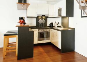 a kitchen with white cabinets and a black counter top at Ferienhaus Jümmers - Sönke in Horumersiel +4 photos