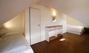 a small room with a bed and a desk at Ferienhaus Jümmers - Sönke in Horumersiel
