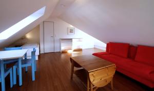 a living room with a red couch and a table at Ferienhaus Jümmers - Sönke in Horumersiel