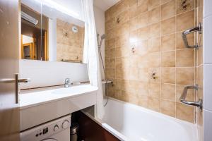 a bathroom with a sink and a bathtub and a mirror at Appartement 46 - Les Coches in La Plagne Tarentaise