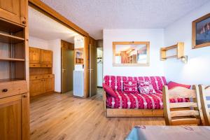 a living room with a red couch and a kitchen at Appartement 46 - Les Coches in La Plagne Tarentaise +17 photos