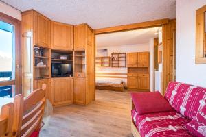 a living room with a couch and wooden cabinets at Appartement 46 - Les Coches in La Plagne Tarentaise