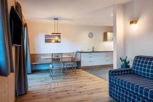 a kitchen and living room with a table and chairs at Mittnackerhof Apartment Ringelblume in Sarntal