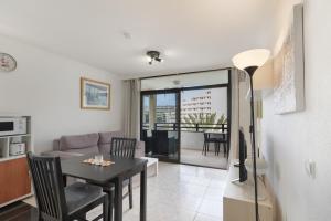 a living room with a table and a dining room at Lirio Blanco de las Dunas Canarias in Playa del Ingles