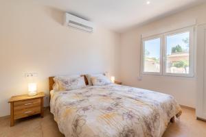a bedroom with a large bed and a window at Casa Antonio Invierno in Cala Llombards +28 photos