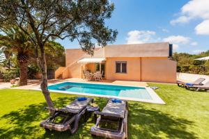 a backyard with a swimming pool and a house at Casa Antonio Invierno in Cala Llombards