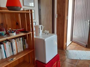 a small refrigerator in a room with a book shelf at Chambre D'hôtes Agapanthe in Feytiat