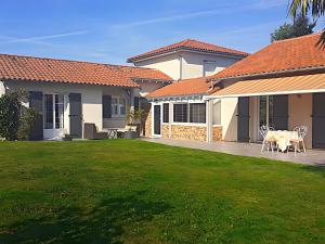 a house with a yard with a table and chairs at Chambre D'hôtes Agapanthe in Feytiat