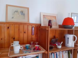 a room with wooden bookshelves and a table with cups at Chambre D'hôtes Agapanthe in Feytiat
