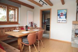 a kitchen and dining room with a wooden table and chairs at Mayen de l'Art d Vivre in Crans-Montana +27 photos
