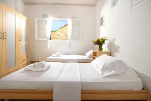 two beds in a white room with a window at Wonderful Villa Chrysta in Mikonos