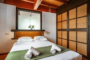 a bedroom with a bed with two pillows and a window at Casa Florenta G3 in Cangas de Onís