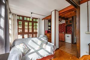 a living room with a white couch and a kitchen at Casa Florenta G3 in Cangas de Onís