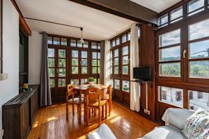 a living room with a table and chairs and windows at Casa Florenta G3 in Cangas de Onís