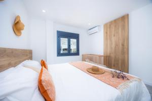a bedroom with a white bed with a hat on it at White suites 2 in Cala d´Or +19 photos
