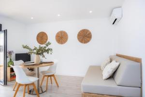 a living room with a table and a couch at White suites 2 in Cala d´Or