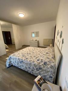 a bedroom with a bed with a blue comforter at Appartamento Primavera in Cazzago San Martino