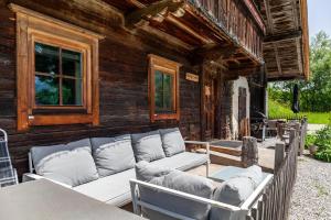a patio with a couch and tables on a house at The Farm in Westendorf