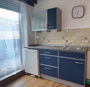 a kitchen with blue cabinets and a sink and a clock at Gästehaus Babel in Pfronten +106 photos