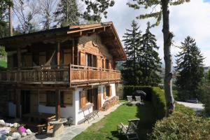a log house with a balcony on the side of it at Mayen de l'Art d Vivre in Crans-Montana