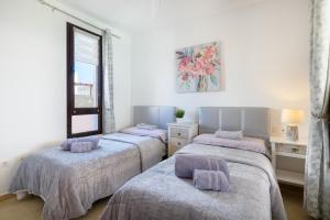 a bedroom with three beds and a window at Villa Petruca in Playa Blanca +29 photos