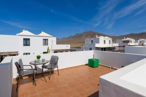 a balcony with a table and chairs on a roof at Villa Petruca in Playa Blanca