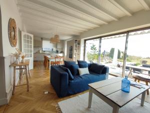 a living room with a blue couch and a table at Villa Cotton-vue mer et jacuzzi-6ch in Plobannalec-Lesconil