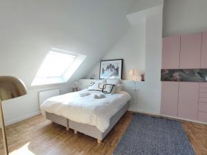 a white bedroom with a bed and a window at Villa Cotton-vue mer et jacuzzi-6ch in Plobannalec-Lesconil