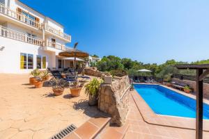 a villa with a swimming pool and a house at Villa Sol in Cala Figuera