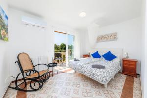a white bedroom with a bed and a balcony at Villa Sol in Cala Figuera +26 photos