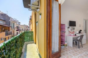 a room with a balcony with a table and a desk at Sole e Amore in Casteldaccia