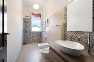 a bathroom with a white sink and a toilet at Mansarda Vialba in Germignaga +20 photos