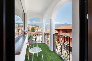 a balcony with two chairs and a table on the grass at Mansarda Vialba in Germignaga