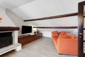 a living room with a couch and a television at Mansarda Vialba in Germignaga