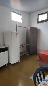 a kitchen with a refrigerator and a table in a room at Cantinho da Lobeira in Alto Paraíso de Goiás