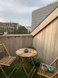 a wooden table and two chairs and a table and chairs on a patio at Cosy Studio in Mechelen by Studio Pila in Mechelen