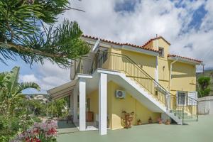 a large yellow house with a staircase at Palati in Kefallonia
