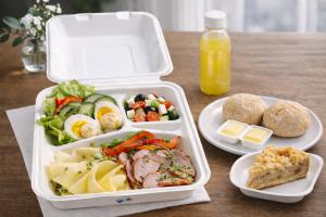 a lunch box with three dishes of food on a table at Rooms Gdynia Orłowo in Gdynia +10 photos