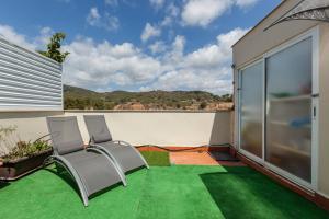 two chairs on a balcony with green grass at La Cantonada in Sant Pere de Ribes