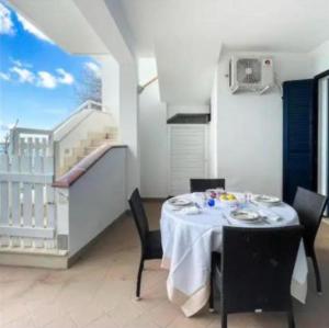 a dining room with a table and chairs and a balcony at Mediterranea in Torre Pali +34 photos